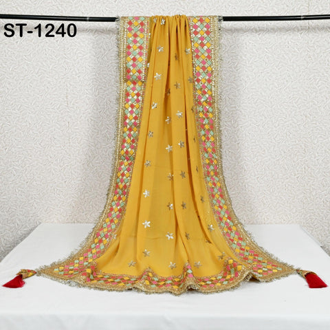a yellow and gold embroidered shawl hanging on a black rod.