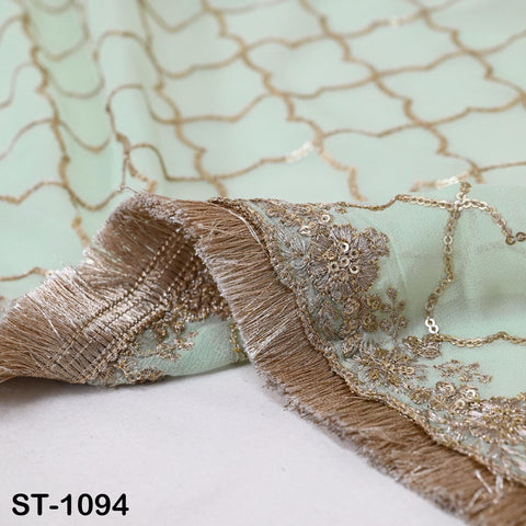 a close-up view of a fabric with intricate embroidery and fringe details, including gold and white elements. The fabric appears to be a light green color, and the image is labeled with the text "ST-1094".