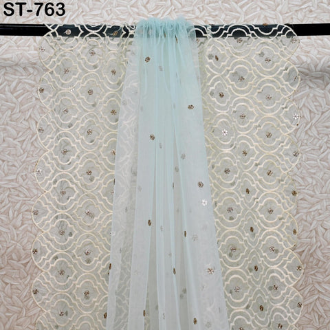 a light blue sheer curtain with a patterned white background hanging on a rod.