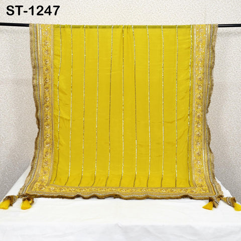 a yellow and gold decorative textile hanging on a rod.