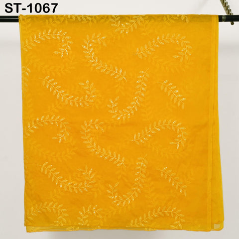 a yellow fabric with a leaf pattern, hanging on a metal bar.