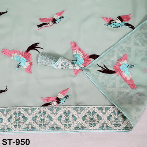 a close-up view of a light blue fabric with a decorative border and embroidered pink and blue birds.