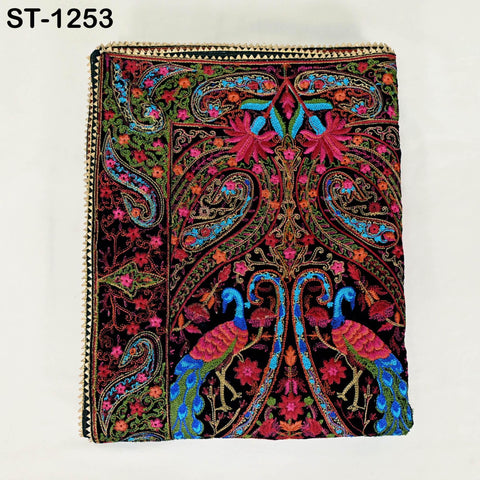 a colorful, intricately embroidered fabric with a paisley pattern. The fabric is adorned with a variety of vibrant colors, including shades of red, blue, green, and yellow, as well as floral and paisley designs. The overall design is visually striking and detailed, showcasing the craftsmanship and artistry involved in creating this textile.