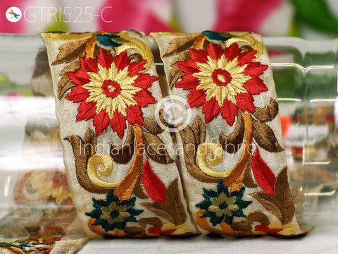 two decorative fabric pieces with intricate floral patterns in red, yellow, and green colors.