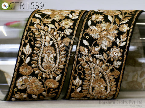 two ornate, decorative fabric pieces with intricate floral and paisley patterns in gold and black. The pieces appear to be made of a shiny, embossed material and are displayed against a plain background.