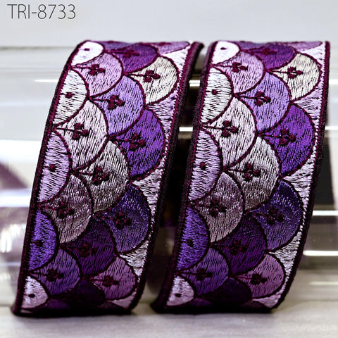 two decorative ribbons with a repeating pattern of purple and white circles, creating a visually appealing and intricate design.