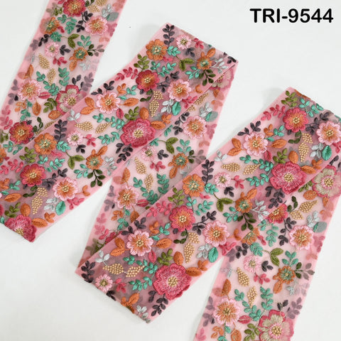 a close-up view of a fabric with a floral pattern, featuring a variety of colorful flowers and leaves. The fabric appears to be a sheer material, as it is transparent and allows light to pass through it. The image does not contain any text or other objects, and the focus is solely on the floral pattern on the fabric.