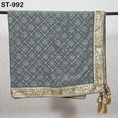 a grey and gold patterned fabric with a metallic border, hanging on a metal bar.