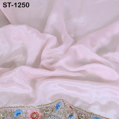 a close-up view of a soft, light pink fabric with a floral pattern on the edge.