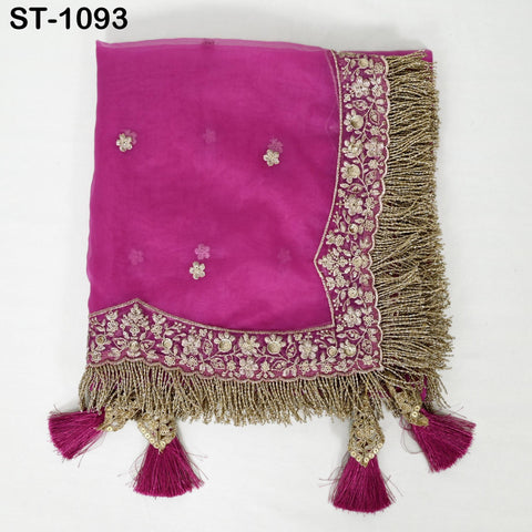 a pink fabric with gold embroidery and fringe details, including tassels.