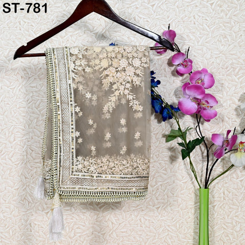 a decorative fabric with a floral pattern hanging on a wooden hanger, accompanied by a vase of pink and blue flowers.