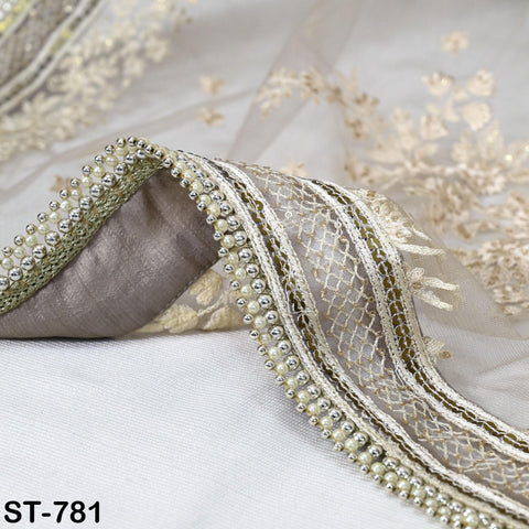 a close-up view of a delicate, intricately embroidered fabric with a beaded and lace trim.