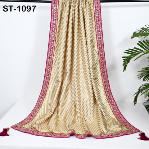 a decorative gold and pink sari with a pink border, hanging on a white background.