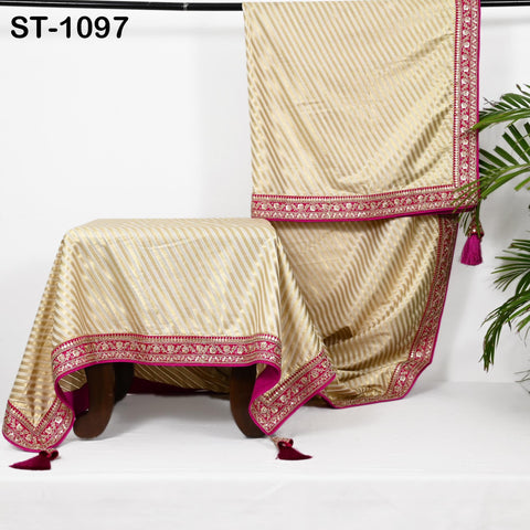 a gold and pink striped tablecloth with a decorative border, placed on a white surface.