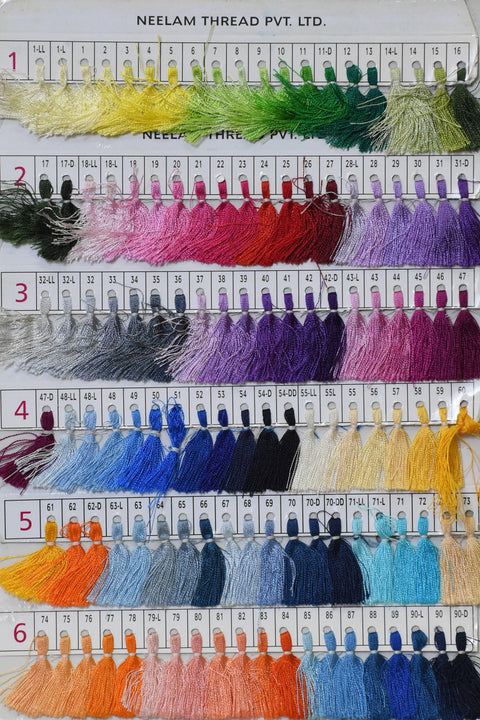 a collection of various colored threads or yarns, arranged in rows and columns, likely for sewing or textile purposes.