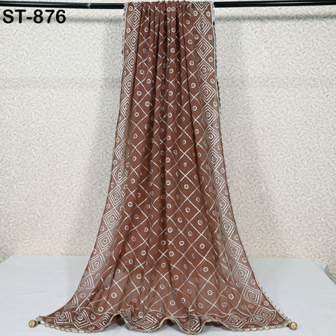a brown and white patterned fabric hanging on a rod against a white background.
