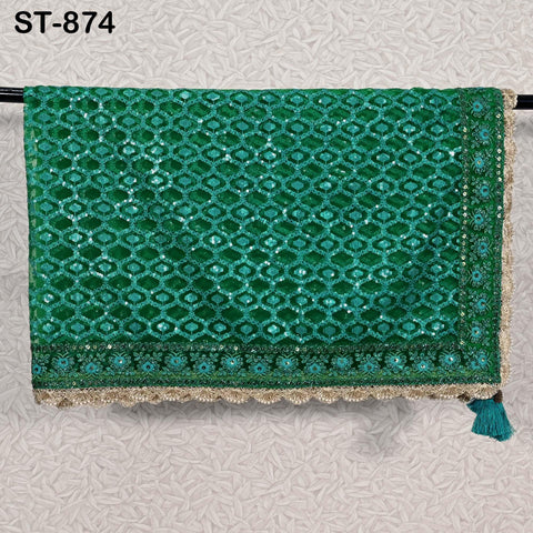 a green and gold embroidered textile hanging on a wall.