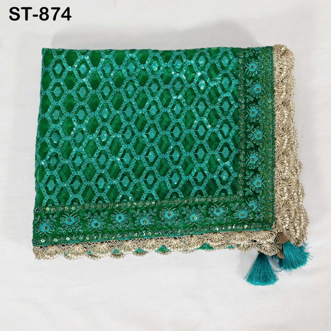 a green and gold embroidered textile with a diamond pattern, featuring a tassel at the bottom.