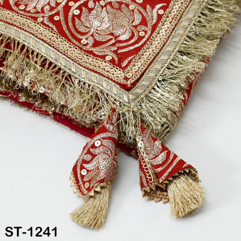 a close-up view of a decorative fabric with intricate embroidery and tassels. The fabric appears to be red and gold, with a floral pattern and fringed edges. The image does not contain any text or other objects, and the focus is on the detailed design and craftsmanship of the fabric.