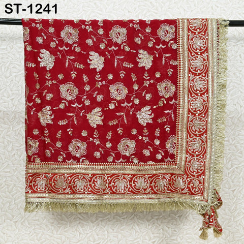 a red and gold embroidered fabric with a floral pattern, hanging on a black rod.