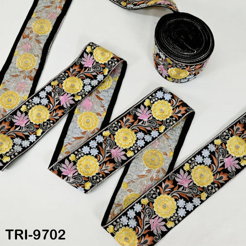 several spools of embroidery ribbon with a floral pattern in shades of yellow, pink, and black. The spools are arranged on a white background, and there is a text label in the bottom right corner that reads "TRI-9702".