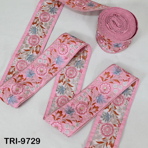 a collection of pink and white floral fabric pieces, including a spool of the same fabric and two pieces of the fabric.