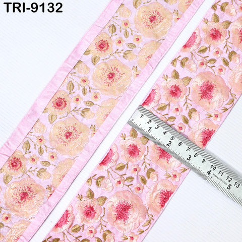 a pink fabric with a floral pattern, and a ruler is placed on top of it, indicating the size of the fabric.
