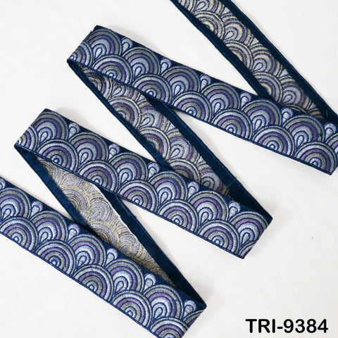a decorative fabric with a repeating pattern of blue and silver circles, arranged in a zigzag or diagonal pattern.