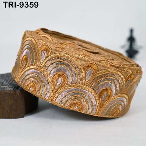 a decorative golden embroidered piece, which appears to be a piece of fabric or textile with an intricate, wave-like pattern.