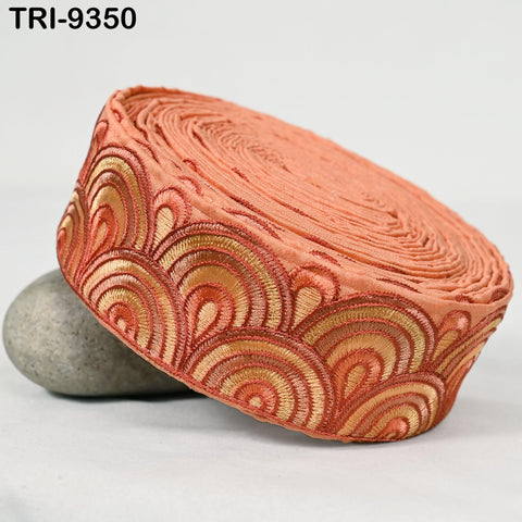 a decorative orange and gold fabric with a repeating pattern of waves or swirls.