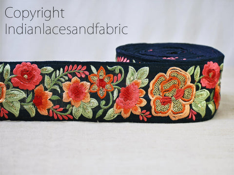 A close-up image of a decorative fabric with a floral pattern in shades of red, orange, and green.