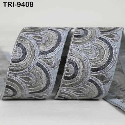 a close-up view of a decorative gray and black fabric with a repeating pattern of circles and swirls.