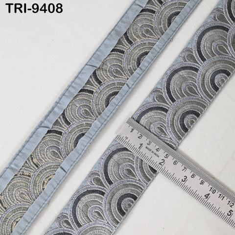 a close-up view of a decorative fabric with a repeating pattern of interlocking circles in shades of gray and black. A ruler is placed on the fabric, indicating its size.