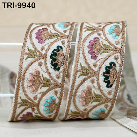 a decorative fabric with a floral pattern, including pink, green, and blue flowers, and a gold border.