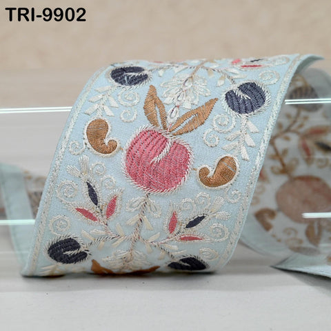 a decorative fabric with a floral pattern, including a large pink flower surrounded by smaller flowers and leaves in various colors.