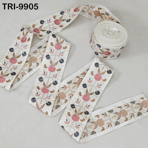 a roll of decorative fabric with a floral pattern, including pink and brown flowers, on a white background.