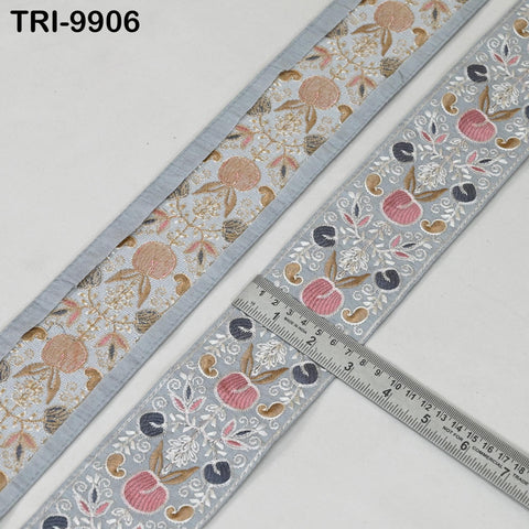 two pieces of fabric with a floral pattern, one with a gray border and the other with a blue border. A ruler is placed between the two pieces of fabric, indicating their size.
