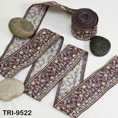 a collection of decorative fabric pieces, including a spool of thread, rocks, and a rolled-up fabric item, all arranged on a white background.