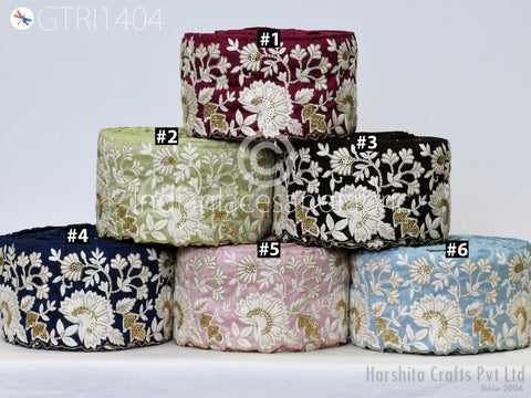 A collection of six fabric rolls with intricate floral embroidery in various colors, including navy blue, green, black, pink, blue, and white.