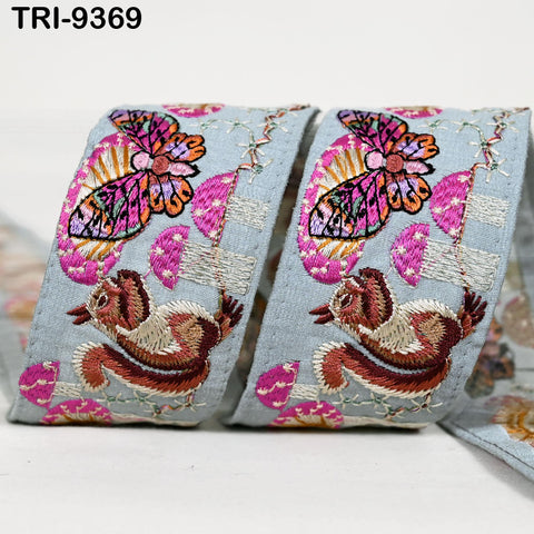 a pair of decorative fabric items with a butterfly and a squirrel design. The butterfly is depicted in a colorful, intricate embroidered pattern, while the squirrel is shown in a more detailed, embroidered style. The fabric items appear to be handmade and feature a variety of colors and patterns, creating a visually appealing and unique design.