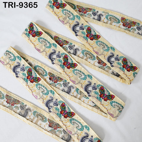 a collection of decorative fabric pieces with a repeating pattern of colorful butterflies and other floral designs. The fabric appears to be a type of ribbon or textile, with a beige color and a vibrant, eye-catching pattern.