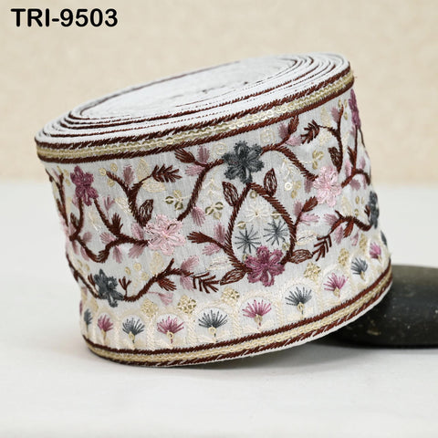 a decorative object with a floral pattern, including pink, purple, and white flowers, along with leaves and branches. The object appears to be a piece of fabric or a decorative item with a floral design.