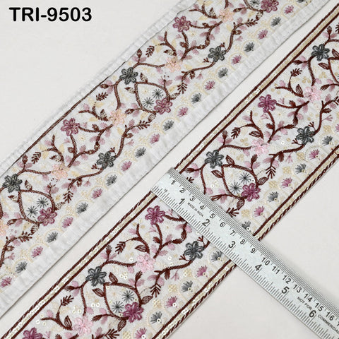 a close-up view of a decorative fabric with a floral pattern, featuring a ruler placed on top of it.