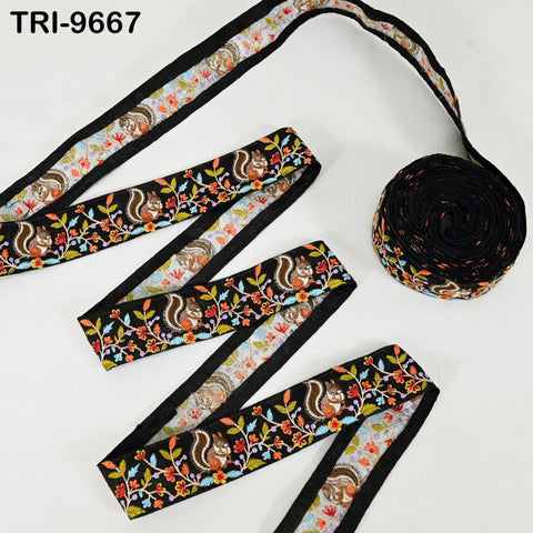 a spool of black thread with a floral pattern and a spool of black thread with a striped pattern, both placed on a white background.