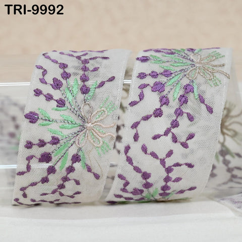 two pieces of white fabric with intricate floral embroidery in shades of purple and green. The text "TRI-9992" is visible in the image.