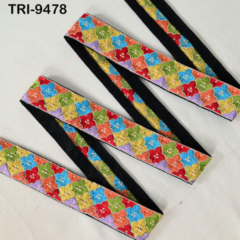 a colorful, patterned fabric with a repeating floral design in various shades of green, yellow, orange, red, and purple. The fabric appears to be a decorative trim or accessory, possibly used for clothing or home decor.