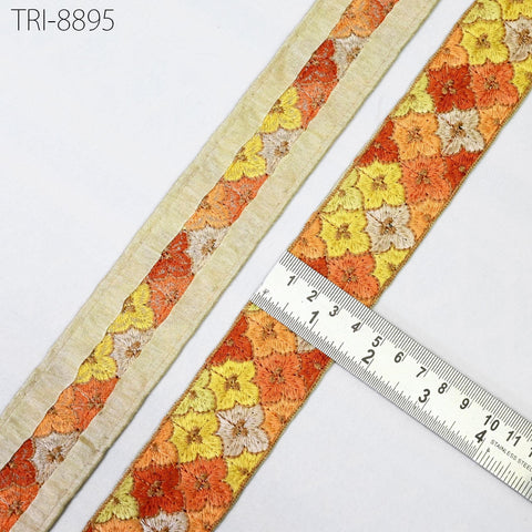 a close-up view of a decorative fabric with a floral pattern, featuring a ruler for scale.