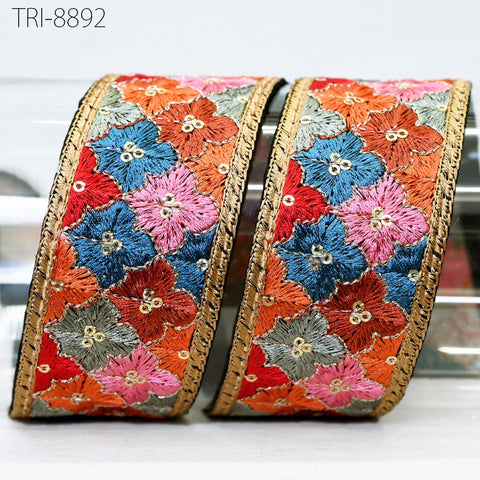 two decorative fabric pieces with a floral pattern in various colors, including red, blue, and pink. The pieces are placed next to each other, with the left piece slightly overlapping the right one.