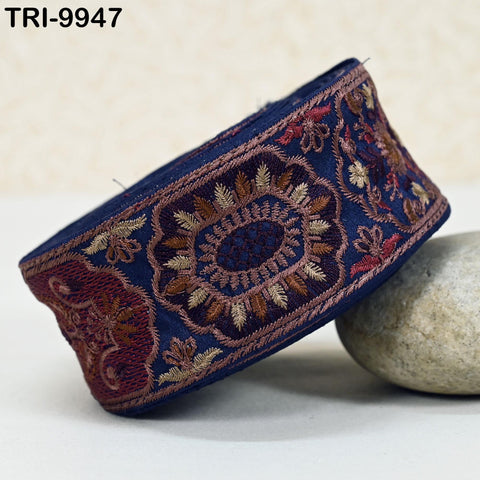 a decorative blue and red embroidered piece of fabric, with intricate patterns and designs, resting on a white surface.