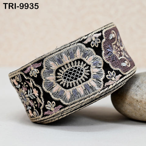 a decorative black and white fabric with intricate embroidered patterns, including floral and geometric designs.
